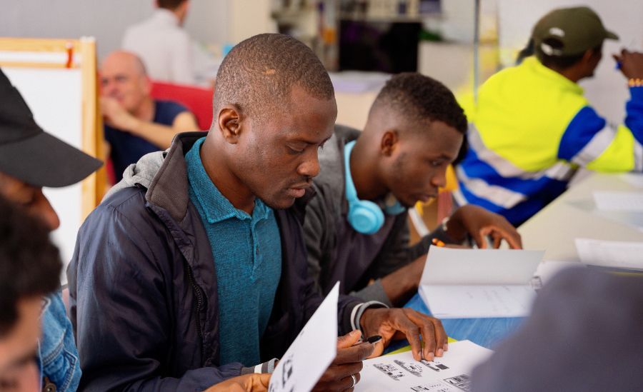 Imagen que muestra un aula con inmigrantes en clase en el proyecto Vínculos en Málaga de Asha-Kiran